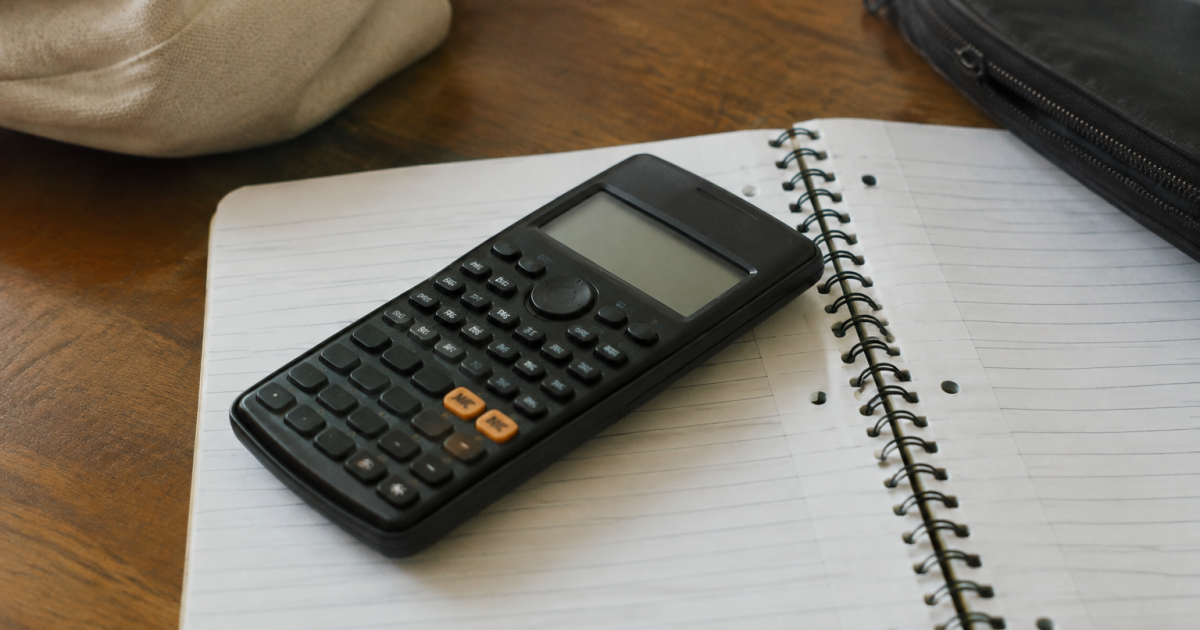 Calculatrice noire posee a plat sur un carnet ouvert