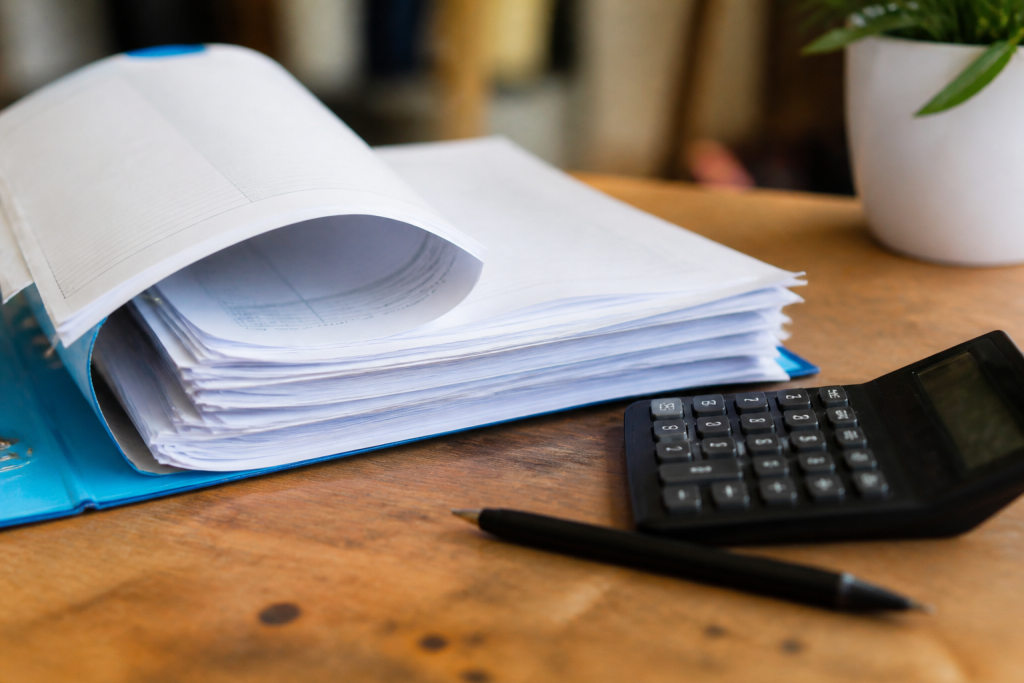 Carnet de factures ouvert sur un bureau avec calculatrice