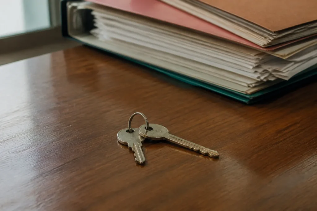 Deux cles posees sur un bureau devant des dossiers