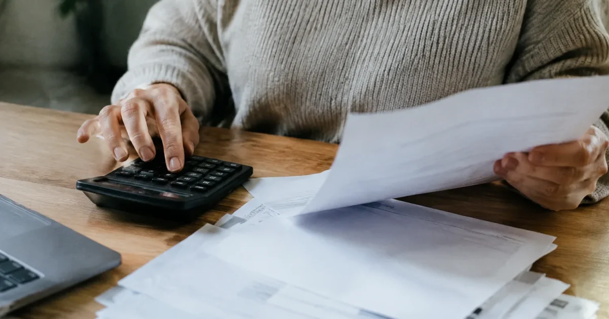 Main tenant une calculatrice pres de factures papier