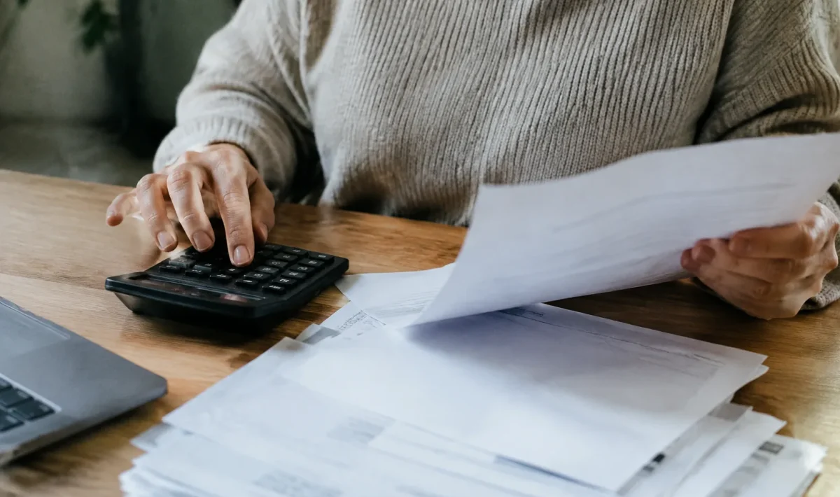 Main tenant une calculatrice pres de factures papier