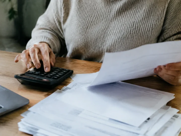 Main tenant une calculatrice pres de factures papier